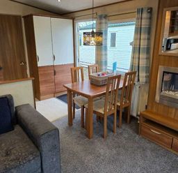 a dining area with a wooden table and chairs at Beacon Fell View Holiday Park - Holiday Accommodation 21653 Preston