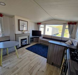 a living room with a television, sofa, and coffee table at Clarach Bay Holiday Village - Holiday Accommodation 21674 in Aberystwyth
