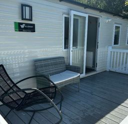 a seating area with wicker chairs and a door at Brynowen Holiday Park - Holiday Accommodation 21677, Borth, Aberystwyth