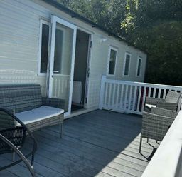 a deck with seating and a door leading to a room at Brynowen Holiday Park - Holiday Accommodation 21677, Borth, Aberystwyth