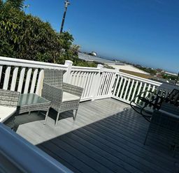 a deck with outdoor furniture and a view at Brynowen Holiday Park - Holiday Accommodation 21677, Borth, Aberystwyth