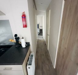 a hallway with a kitchen area on the left at Lido Beach Holiday Park - Holiday Accommodation 21682, Prestatyn
