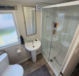 a bathroom with a shower, sink, and toilet at Lido Beach Holiday Park - Holiday Accommodation 21682, Prestatyn