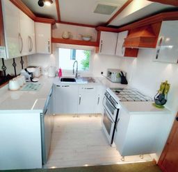 a kitchen with cabinets, countertop, stove, sink, and appliances at Hafan y Mor Haven - Holiday Accommodation 21715 in Pwllheli