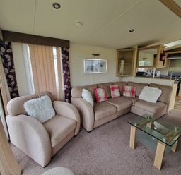 a seating area with a brown sofa and armchairs in Clarach Bay Holiday Village - Holiday Accommodation 21850, Aberystwyth
