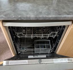 an open dishwasher with racks and a silver control panel at Clarach Bay Holiday Village - Holiday Accommodation 21850, Aberystwyth