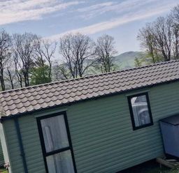 a cabin with a pitched roof and a storage box outside at Woodlands Holiday Park - Holiday Accommodation 21859 in Twywn