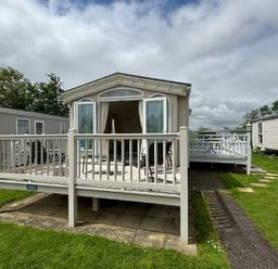 a holiday caravan with a deck and seating area at Butlins Skegness - Holiday Accommodation 22071 in Ingoldmells