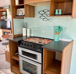 a kitchen area with an oven, countertop, and utensils at Valley Farm Holiday Park - Holiday Accommodation 22153, Clacton-on-Sea