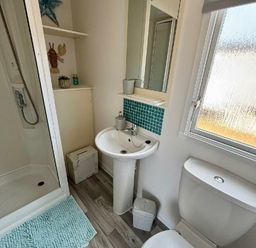 a bathroom with a sink, shower, mirror, and window at Valley Farm Holiday Park - Holiday Accommodation 22153 Clacton-on-Sea