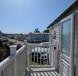 a view from a porch showing caravans and a parked car at Ty Gwyn Caravan Park - Holiday Accommodation 22189 in Abergele