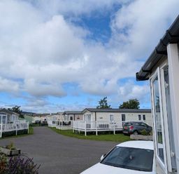 a row of caravans with a cloudy sky at Ty Gwyn Caravan Park - Holiday Accommodation 22189 in Abergele