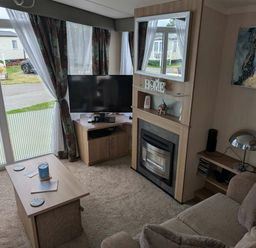 a living room with a television and a fireplace at Ty Gwyn Caravan Park - Holiday Accommodation 22189, Abergele
