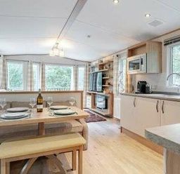 a kitchen and dining area with a table set for two at Kelling Heath Holiday Park - Holiday Accommodation 22244 in Holt