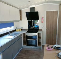 a kitchen with a sink, stove, and countertop at Lyons Winkups and Primrose - Holiday Accommodation 22330, Towyn