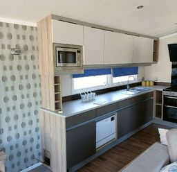 a kitchen area featuring cabinets, a sink, a built-in microwave, and a dishwasher at Lyons Winkups and Primrose - Holiday Accommodation 22330 Towyn