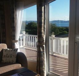 a seating area with large windows overlooking a body of water at Waterside, Paignton - Holiday Accommodation 2287, Paignton