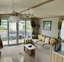 a living room with a sofa and sliding glass doors at Lakeland Leisure Park - Holiday Accommodation 3166 Flookburgh