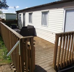 a wooden deck with a railing leading to a mobile home at Seven Bays Park (Maribou) - Holiday Accommodation 3966, St Merryn