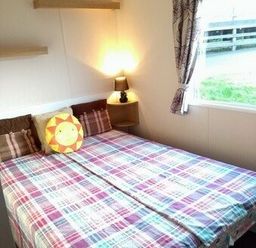 a bedroom with a double bed and a lamp on a nightstand at Swanage Bay View - Holiday Accommodation 464, Swanage
