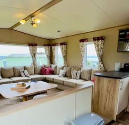 a living room with a sofa, cushions, and a table at St Andrews Holiday Park - Holiday Accommodation 609 in St. Andrews