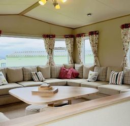 a seating area with a sectional sofa and a round table at St Andrews Holiday Park - Holiday Accommodation 609 St. Andrews