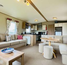 a living room and kitchen area with a sofa, dining table, and appliances at St Andrews Holiday Park - Holiday Accommodation 609 St. Andrews