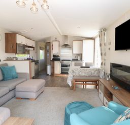 A living room with a sofa and dining area at Hopton Holiday Village - Holiday Accommodation 632 Hopton-On-Sea