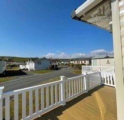 a view from a balcony overlooking holiday homes and green landscape at Greenacres Holiday Park - Holiday Accommodation 6757 Porthmadog
