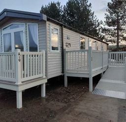 a holiday caravan with a ramp and wooden deck at Reighton Sands Holiday Park - Holiday Accommodation 6837 in Filey