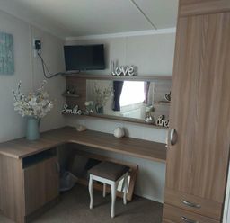 a corner dressing area with a mirror and storage at Reighton Sands Holiday Park - Holiday Accommodation 6837, Filey