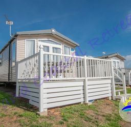 a holiday caravan with a deck and patio furniture at Grand Coastal Retreats in an outdoor setting