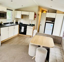 a kitchen and living area with a dining table and seating at Hafan y Mor Haven - Holiday Accommodation 7421 in Pwllheli