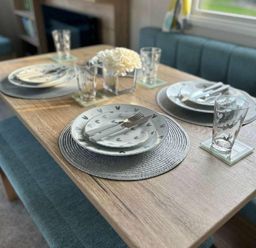 a dining table set with plates, utensils, and glasses at Butlins Minehead - Holiday Accommodation 826 in Minehead