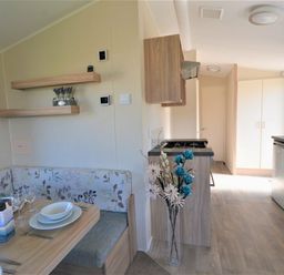 a dining area with a table set for four and a kitchen in Perran Sands - Holiday Accommodation 8302, Perranporth