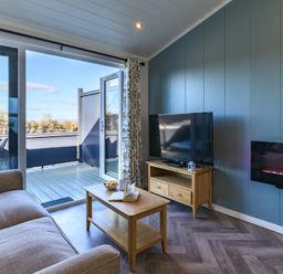 A living room with a television and sliding door at Coniston in Penrith