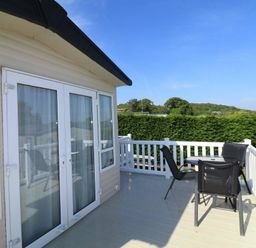a balcony with chairs and a table overlooking greenery at White Acres Holiday Park - Holiday Accommodation 895 in Newquay