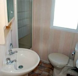 a small bathroom with a sink, toilet, shower, and window at Perran Sands - Holiday Accommodation 9159 in Perranporth