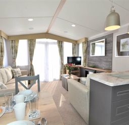 a living room with a sofa, TV, and dining table at Perran Sands - Holiday Accommodation 9871 in Perranporth