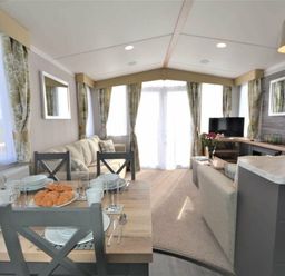 a living room with a dining table set for breakfast at Perran Sands - Holiday Accommodation 9871 Perranporth