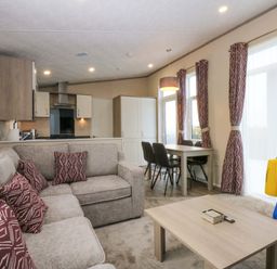 A living room with a sofa and dining area at Blue Skies in Caernarfon