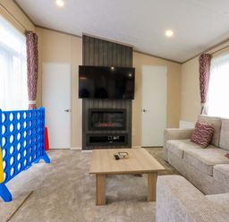 A living room with a sofa and television at Blue Skies in Caernarfon
