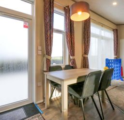A dining room with a table and chairs at Blue Skies in Caernarfon