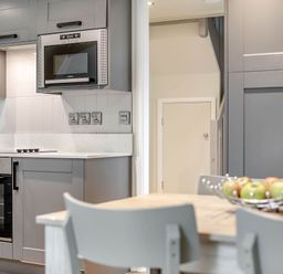 A kitchen with appliances and a table with a bowl of apples at St Ives Studio in Praze-An-Beeble