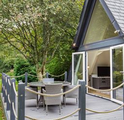 An outdoor deck with a table and chairs at St Ives Studio in Praze-An-Beeble