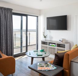 A living room with a television and coffee table at Ferry Hills in Laugharne