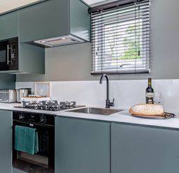 A kitchen with a sink and stove at Prion Spa in Llandyrnog