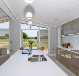 A kitchen with a sink and countertop overlooking the garden at Darwin Retreat in Wigton