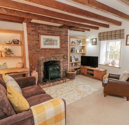 A living room with a fireplace and furniture at 21 High Street in Scarborough