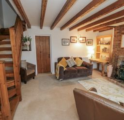 A living room with a sofa and a staircase at 21 High Street, Scarborough